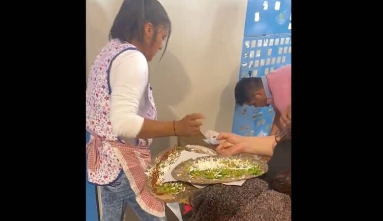 Una señora instala su puesto de tlayudas en el AIFA; aprovecha que no hay locales de comida